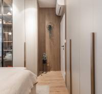 A cozy bedroom with a wood-patterned floor and a glass wardrobe in a 3-room apartment.