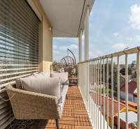 A balcony of a 3-room apartment in Bratislava - Ružinov with outdoor seating and wooden decor.