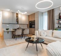 A stylish living room with a kitchen in a 3-room apartment, light shades, wooden decor flooring.