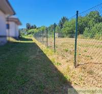 Grassy plot with a fence in Hosťová, ideal for living.