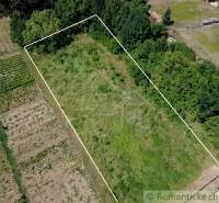 Residential plots in Hosťová, surrounded by nature and trees, ideal for a garden.