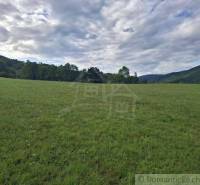 A vast green meadow surrounded by forests and hills in the vicinity of Horný Tisovník, Land - residential.