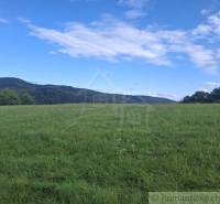Green meadow with hills and sky in Horný Tisovník, suitable for residential plots.