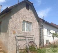 A family house in Šiatorská Bukovinka with stone stairs and a garden, with a blue sky in the background.