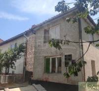 A family house in Šiatorská Bukovinka, surrounded by greenery and trees, with a sloped roof.