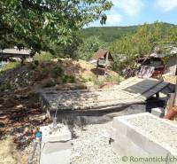 The backyard of a family house in Šiatorská Bukovinka with a pile of soil and trees.