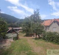 A family house in Šiatorská Bukovinka with a view of the hills, a garden with trees and vines.
