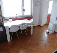 Dining room in a 2-room apartment with a white table and brown floor.
