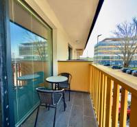 The balcony of a 2-room apartment on Mikovíniho Street in Trnava with seating and a view of the street.