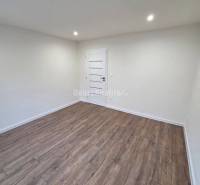 A room in a 3-room apartment with white walls and a wooden decor floor.