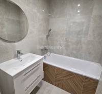 Bathroom with a bathtub and a white cabinet in a 3-room apartment.