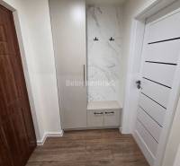 Hallway with a wardrobe and hooks, marble decor, floor with wooden decor.