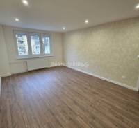 Living room with wood-patterned flooring in a 3-room apartment, light and simplicity.