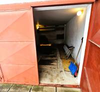 A garage in a family house in Kameňany with open metal doors and tools.