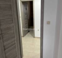 Interior of a 2-room apartment with tiled flooring, wooden decorated doors.