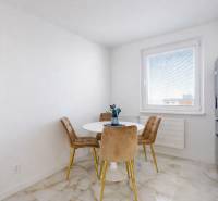 Dining area in a 3-room apartment with a marble floor and four chairs.