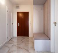 Entrance hallway in a 3-room apartment with tiles and an upholstered bench.