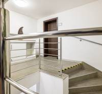 A staircase with a metal railing and neutral walls in a family house.