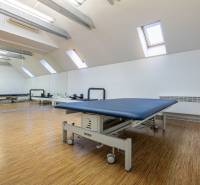 Physiotherapy room in a family house with a wooden decor floor and mirrors.