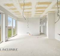 A spacious cottage with white walls and large windows, and a floor with a wooden decor.