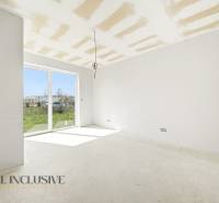 Spacious cottage with a large window and a view of the green surroundings.