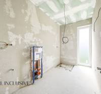 The interior of the cottage with unfinished walls and preparation for the installation of sanitary equipment.