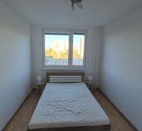 Bedroom with a double bed and wooden decor flooring in a two-room apartment.