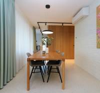 Dining room in a 4-room apartment with a wooden table and decorative painting on the wall.