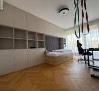 A room in a 4-room apartment with a bed, a table, and a floor with a wooden decor.