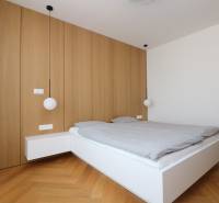 A bedroom with pendant lights and a wooden decor floor in a 4-room apartment.