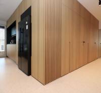 A kitchen in a 4-room apartment with wood decor, a black refrigerator, and white tiles.