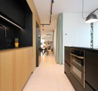 A kitchen in a 4-room apartment with wooden decor and black accessories.