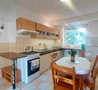A kitchen with a kitchenette and a dining table in a 2-room apartment.