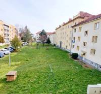 Apartment buildings and a parking lot between green courtyards on Obrancov Mieru Street in Prešov.