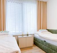 A bedroom with two beds and a wooden decor floor in a 3-room apartment.