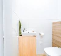 Bathroom in a 3-room apartment with a wooden decor floor and a simple sink.