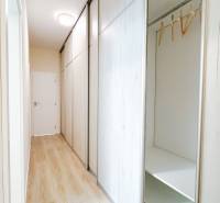 A hallway with a sliding wardrobe and a wooden decor floor in a 3-room apartment.
