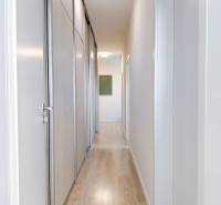 A hallway in a 3-room apartment with a wooden decor floor and built-in wardrobes.