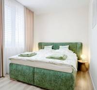 Bedroom in a 3-room apartment with a bed in green upholstery and a floor with a wooden decor.