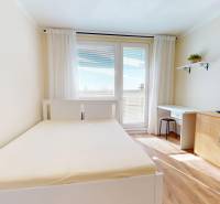 A room with a bed, a desk, and storage space in a studio apartment.