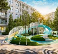 A children's playground at a residential development in Phuket with a large slide and greenery.