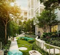 The exterior of a residential development in Phuket with a children's playground surrounded by greenery.