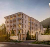 Apartment construction in Phuket, an elegant building surrounded by greenery at dusk.