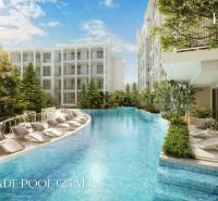 A pool with loungers surrounded by buildings under construction of apartments in Phuket.