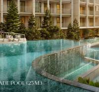 A pool with cascades during the construction of apartments in Phuket with loungers and greenery.