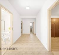 A hallway in a family house with doors to the rooms and tiles on the floor.