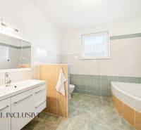 Bathroom with a bathtub, mirror, and storage space in a family house.
