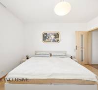 A bedroom in a family house with simple furniture and a wooden decor floor.