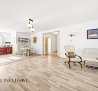 Bright living room with kitchen, wooden decor flooring, dining area.