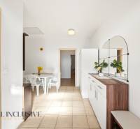 Interior of a family house with a white table and chairs, with a large mirror on the wall.